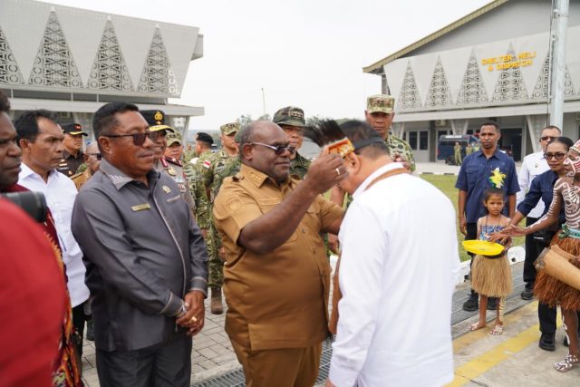 Gubernur Meki Nawipa memasang topi berbulu kasuari kepada Menko Polkam, Dudung Abdurahman